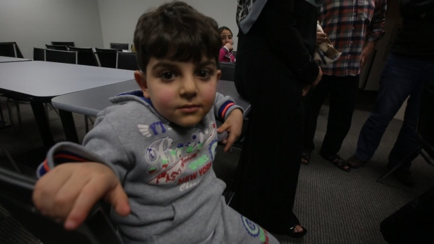 A young Syrian sits in a downtown hotel while he and his family wait for more permanent accommodation in Canada. Many Syrians say they are thankful to be in the hotel.