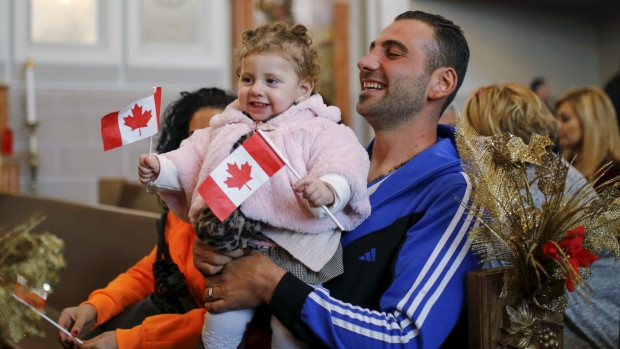 Syrian refugee Kevork Jamgochian holds his daughter Madlin at the St. Mary Armenian Apostolic Church during a welcome serivice at the Armenian Community Centre of Toronto in January 2016. About 7,000 Syrian refugees have already settled in Ontario since Dec. 10.