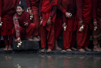 尼泊尔妇女深穿红袍 半裸洗圣浴祈福