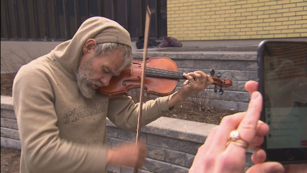 Mark Landry plays a song on his brand new violin, which the homeless man received as a gift from the Orchestre Métropolitain and a local violin shop after his old one was stolen.