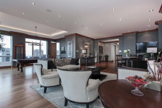 The living room features panoramic views of the city and custom controlled sunshades.