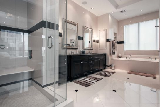 The ensuite bathroom features twin sinks and a separate glass-walled shower.