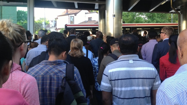 Commuters line up for shuttle buses at Pape station Wednesday morning after subway service was suspended on line 2 between Pape and St. George due to a fire at track level.