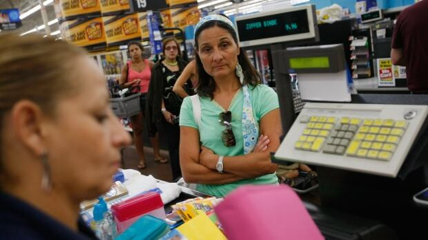 Customer Lucia Buccico waits to pay for her purchases at the checkout counter at a Walmart store.