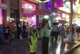 哈尔滨环卫工为冒雨执勤武警战士打伞挡雨
