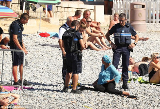 武装警察强制穆斯林妇女脱下泳衣一幕