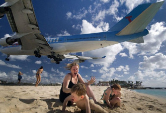 惊险！波音747飞机贴着游客头顶飞过海滩