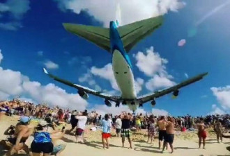 惊险！波音747飞机贴着游客头顶飞过海滩