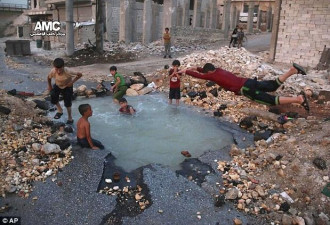 叙利亚阿勒颇遭袭 地面开裂成孩子们的“泳池”