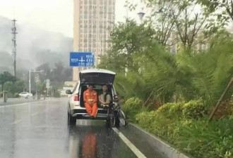 警察大雨中打开车后尾箱盖 陪环卫工一起避雨