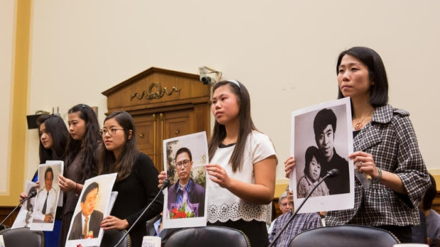 Ti-Anna Wang (centre, in black) says Prime Minister Justin Trudeau should 'unequivocally demand' the release of her father, Wang Bingzhan.