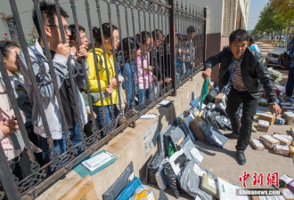 中国高校迎物流高峰 学生隔栅栏取快递场面混乱