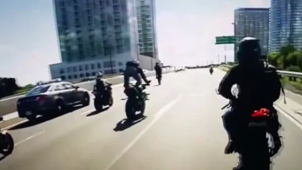 A video shows a motorcycle mob stunt riding in front of Toronto police on the Gardiner Expressway.
