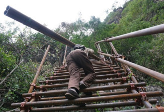 悬崖村绝壁修路 村民背1500根钢管上山造天梯