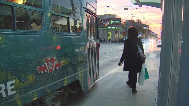 A TTC customer prepares to board the 501 Queen streetcar. The 501 will not return its regular route until early December when water main replacement work is expected to be completed.