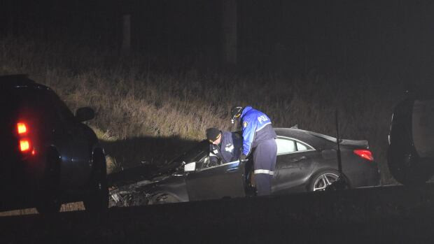 Ontario Provincial Police inspect a car after a crash on Sunday evening killed a mother and critically injured her baby. A male driver has been arrested and is facing charges that will include impaired driving causing death.
