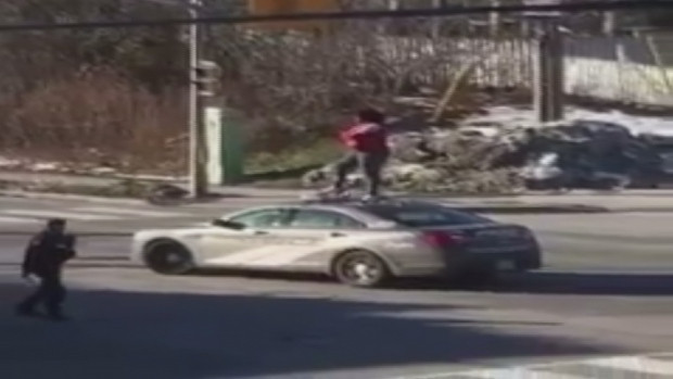 Toronto police attempt to apprehend a woman who climbed onto a cruiser at Finch Avenue West and Milady Road on Jan. 1.