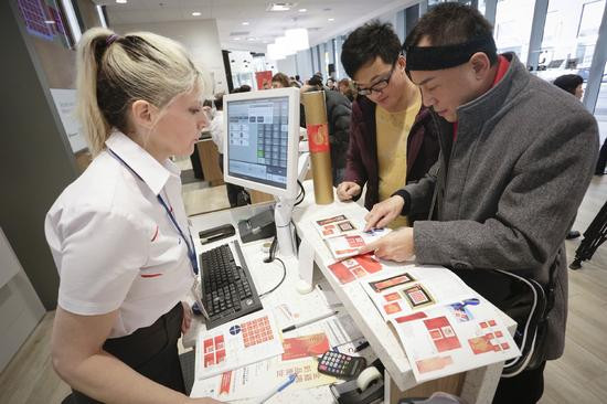 人们在一家邮局�买�国鸡年生肖邮品
