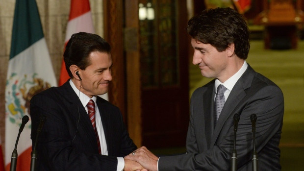 Prime Minister Justin Trudeau and Mexican President Enrique Pena Nieto clasp hands at a joint news conference on Parliament Hill in Ottawa on Tuesday, June 28, 2016. Canada recently dropped a visa requirement for travellers from Mexico.