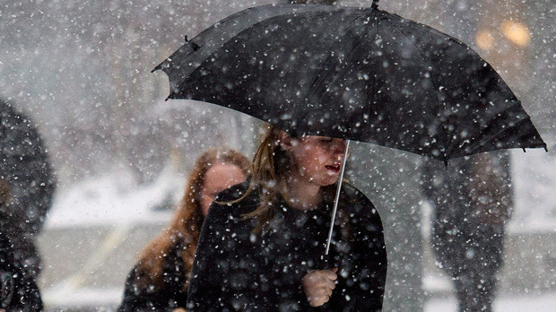 A woman uses an umbrella to take cover in Toronto in this file photo. (The Canadian Press/Nathan Denette)
