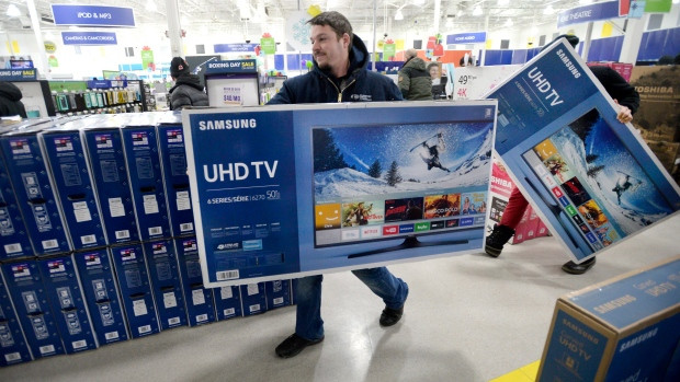 A customer carries a TV to the checkout at a Best Buy store in Ottawa on Boxing Day, Monday, Dec. 26, 2016. Between six and nine per cent of all goods sold each year by Canadian retailers will be returned, the bulk of them in the post-holiday period.