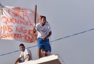 巴西监狱暴动现场:囚犯爬上屋顶手持武器示威
