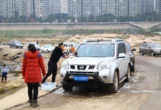 重庆码头成自助洗车场 百余辆车排队在江边洗车