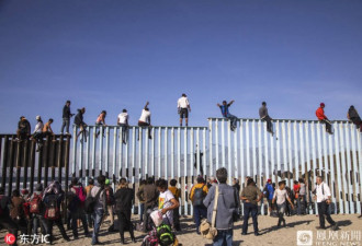 部分中美州移民抵达当地 攀爬美墨边境的隔离墙