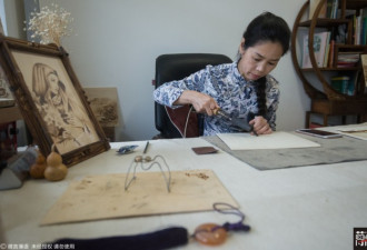 女子靠电铁笔木板上作画 年入20万 5年买房
