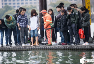 台湾女游客手机掉进西湖 大汉路过 徒手捞起