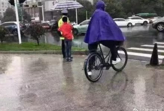 这位为雨中执勤交警打伞的红衣少年，你真暖！