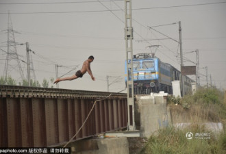 印度男孩火车驶来前玩特技 纵身跃入恒河