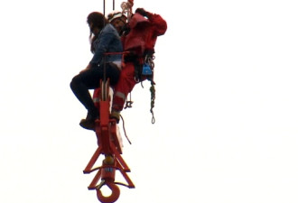 20多岁美女爬上30米高吊塔 消防员花3小时救下
