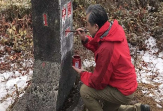 中国外长王毅单膝跪地为“共和国1号碑”上漆