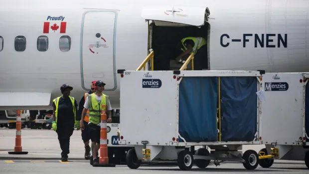 Baggage handlers are seen removing baggage from a WestJet aircraft on Friday, July, 28, 2017. Ground crew workers at Pearson airport have walked off the job after rejecting the latest offer from Swissport. Picket lines have been set up at Pearson's Terminal 3 and a cargo terminal near Swissport's administrative offices.