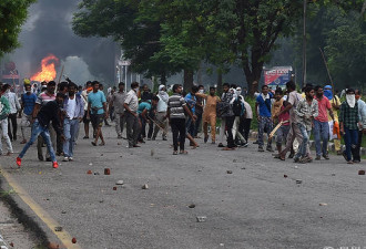 印度大骚乱致31死 多辆汽车被烧浓烟滚滚