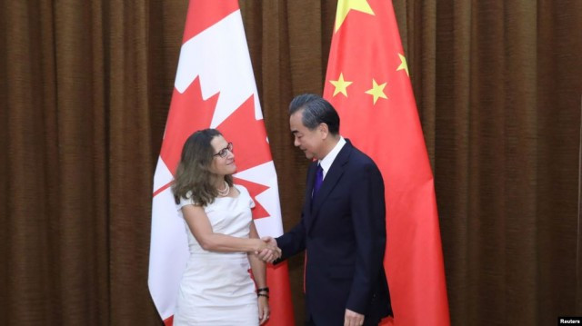 加拿大外长弗里兰与�国外交部长王毅握手。(2017年8月9日)