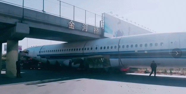 哈尔滨街头：飞机被卡在大桥下面