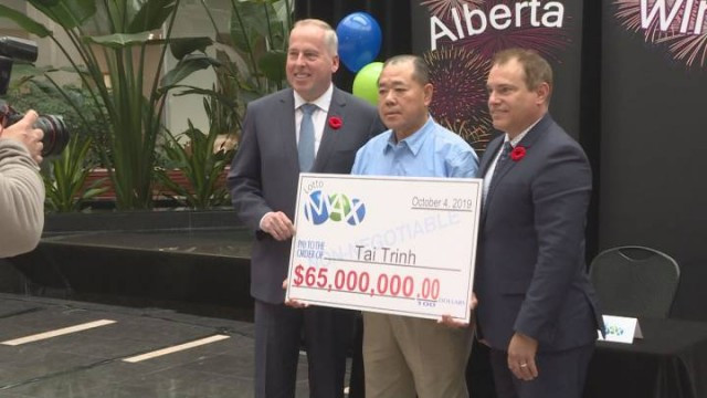 A Calgary man holds his new found winnings on Thursday after being named the official winner of Octobers LottoMAX jackpot. .