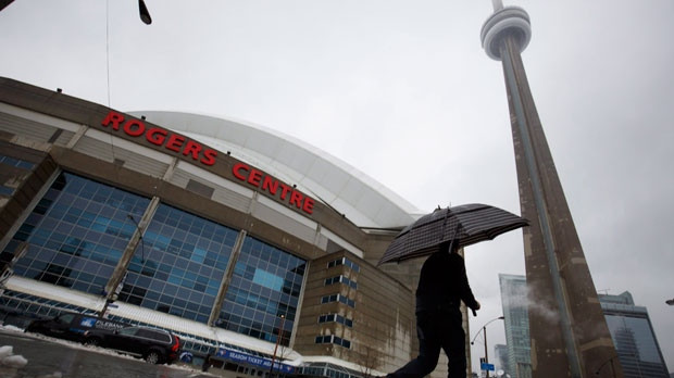 A man walks by the Rogers Centre as reports of falling ice from the CN Tower sparked a closure of parts of the area on Toronto on Monday, April 16, 2018. THE CANADIAN PRESS/Cole Burston