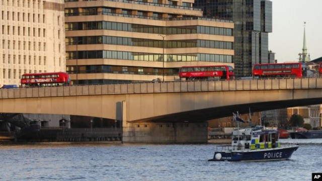 一艘英国�方船只从泰晤士河上向伦敦桥驶去。枪击事件发生后伦敦桥上停放着被丢弃的公共汽车。（2019年11月29日）