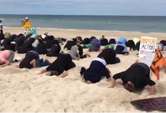 抗议？近百人跪在澳大利亚海滩 把头埋在沙子里