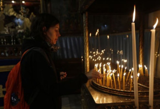 基督徒在伯利恒的圣诞教堂中点亮蜡烛