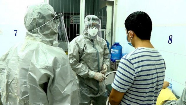 胡志明市发现两名�汉肺炎确诊病例（图右立者及躺在病床者），医�人员如临大敌。(Getty Images)
