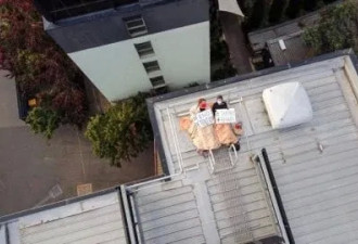 有人把自己拴在墨尔本酒店楼顶，还拉横幅抗议