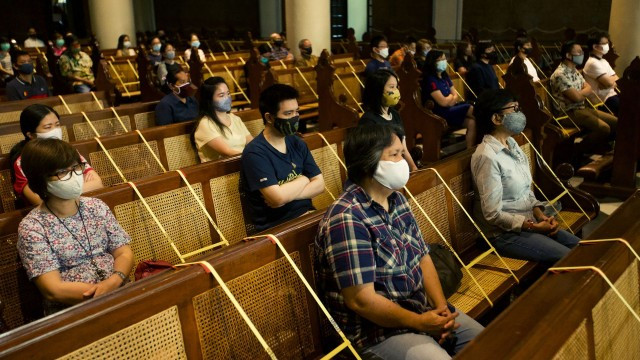 印尼新冠肺炎疫情：7月12日，雅加达民众在教堂重开后参加弥撒，他们都戴着口罩并保持社交距离。（Reuters）