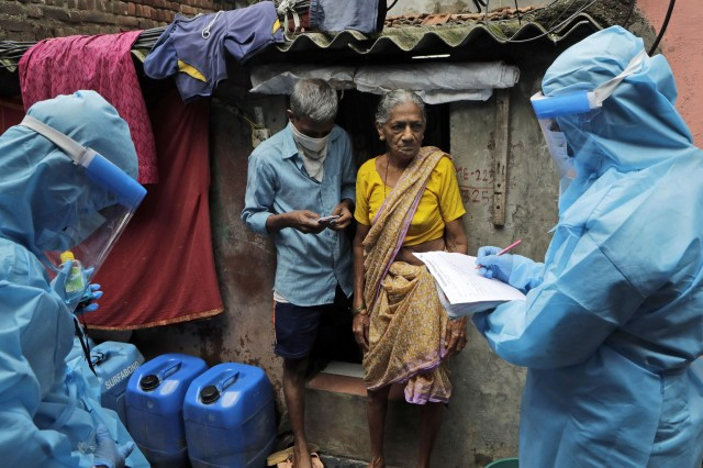 印度新冠肺炎疫情：7月11日，印度�买的医护人员检查贫民窟居民是否已感染新冠肺炎。（AP）