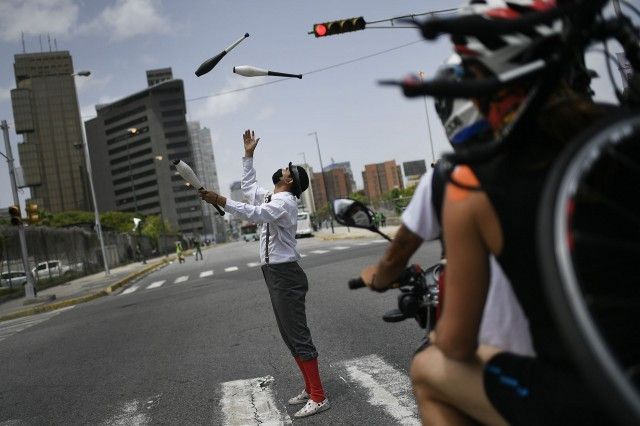 委内瑞拉新冠肺炎疫情：7月11日委内瑞拉一名街头表演者在加拉加斯的马路上表演杂技。（AP）