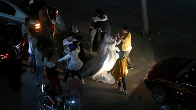 7月10日，受疫情影响，埃及宴会厅关�，开罗一对新人只能与亲友在街上庆祝新婚。（Reuters）