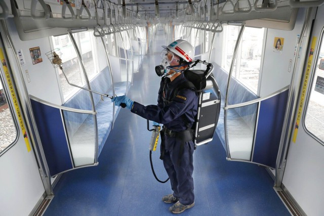 7月9日，日本东京一名地铁员工在地铁内消毒车厢。（AP）